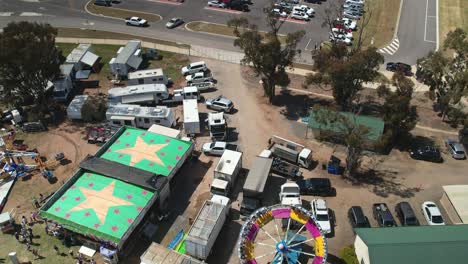 Yarrawonga,-Victoria,-Australia---7-October-2023:-Aerial-tilting-down-to-view-people-and-the-spinning-Tornado-amusement-ride-at-the-Yarrawonga-Show