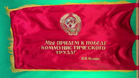 Die-Sowjetische-Paradeflagge-Mit-Propagandaslogans-Weht-Vom-Fahnenmast-Mit-Grünem-Hintergrund