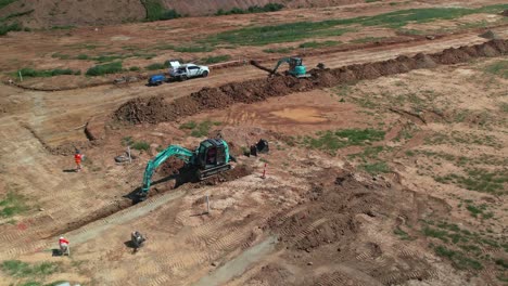 Yarrawonga,-Victoria,-Australia---20-October-2023:-Two-workers-near-an-excavator-digging-a-trench-on-the-new-stage-at-Silverwoods-Estate-Yarrawonga,-Victoria,-Australia