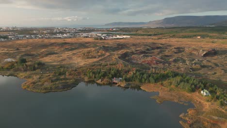 Aerial-view-of-cabin-surrounded-by-autumnal-woods-next-to-Reykjavik,-Iceland