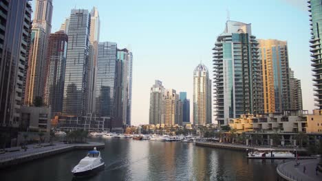 Luxury-Dubai-Marina-skyscrapers,-cruise-boat-and-promenade-on-a-beautiful-summer-evening,-Dubai,-United-Arab-Emiretes