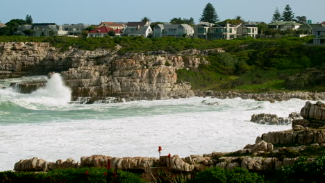 Seaside-properties-in-Hermanus-overlooks-ocean-waves-crashing-into-rocky-shore