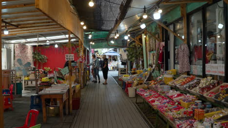 People-Travel-in-Gyeongamdong-Railroad-Town-in-Gunsan,-Railway-Tracks-Through-Narrow-Street-With-Old-Retro-Korean-Shops