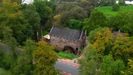 Drohne,-Die-Am-Mittelalterlichen-Historischen-Wassermühlenrad-In-Niederländischer-Landschaft-Herabsteigt