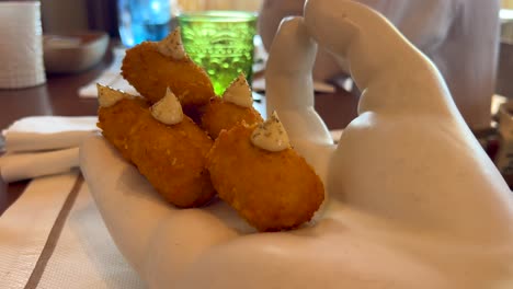 Traditional-Spanish-croquettes-with-iberian-ham-starter-in-Bibo-Beach-House-Tarifa-restaurant,-tapas-of-Dani-Garcia-in-Spain,-4K-shot