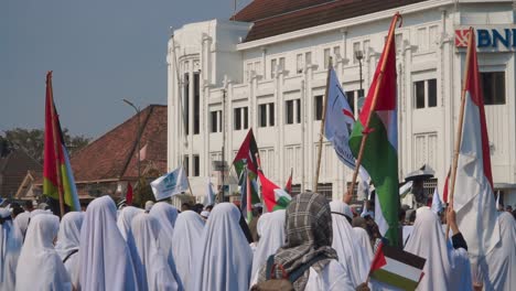 Group-of-asian-women-with-Hijab-veil-waving-Palestinian-flags-on-street-in-Indonesia-at-Demonstration-for-independence---War-between-Israel-and-Hamas-2023---static-slow-motion