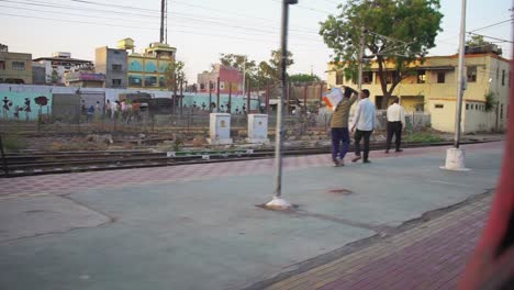 POV-Aus-Dem-Fenster-Eines-Zuges,-Der-An-Einem-Indischen-Bahnsteig-Vorbeifährt