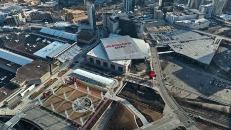 Aerial-top-down-shot-of-State-Farm-Arena-rooftop-with-driving-cars-on-road-in-Atlanta-City