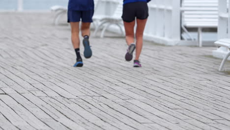 Legs-Of-People-Running-In-The-Boardwalk-With-Benches