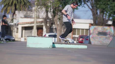 An-adult-man-wearing-headphones-practices-tricks-on-a-skateboard