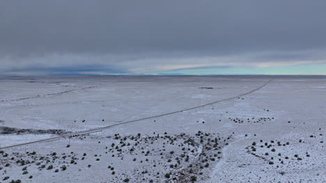 Super-wide-drone-shot-of-snowy-road-in-the-southwest
