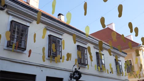 Gelbe-Fußabdruckausschnitte-Hängen-Auf-Der-Straße-Während-Des-Spancirfest-Festivals-In-Varazdin,-Kroatien