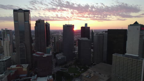 Drone-shot-flying-backwards-away-from-the-skyline-of-Dallas,-evening-in-TX,-USA