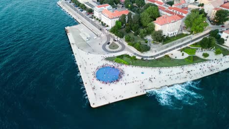 Aerial-of-the-Zadar-Sunset-Monument-Sea-Coast,-also-known-as-the-Monument-to-the-Sun,-is-a-captivating-and-innovative-art-installation-located-in-the-beautiful-Croatian-city-of-Zadar