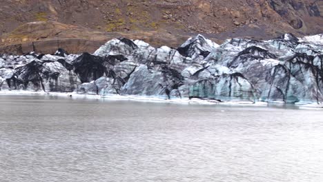 Vista-Panorámica-Aérea-De-La-Pared-De-Hielo-Rocoso-Del-Glaciar-Que-Se-Derrite-En-Islandia