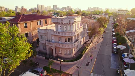 Aerial-view-establishing-the-Sermini-Palace,-Los-Jesuitas-Castillito-of-eclectic-style-in-the-Santa-Isabel-neighborhood-of-Providencia,-Santiago-Chile-Sunset-with-rays