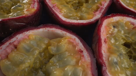 Close-up-rotating-passion-fruits,-juicy-tropical-maracuya,-tasty-exotic-fruit,-4K-macro-shot