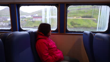 Female-tourist-enjoys-view-on-Faroe-Islands-from-boat,-water-bus