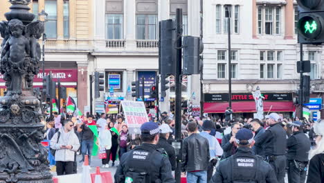 Demonstration-in-urban-square-with-diverse-crowd-and-police-presence---pro-palestine-in-London,-UK