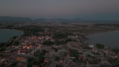 Luftaufnahme-über-Beleuchtete-Seite-Der-Altstadt-Am-Mittelmeer-In-Richtung-Des-Taurus-Gebirges-Bei-Sonnenuntergang
