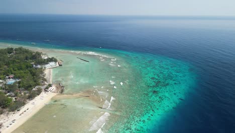 Aerial-of-Trawangan-East-Beach,-nestled-in-Indonesia,-is-a-slice-of-tropical-heaven-that-beckons-travelers-with-its-tranquil-beauty-and-serene-charm