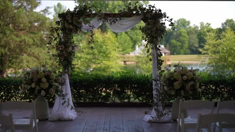 meticulously-designed-wedding-ceremony-setup-surrounded-by-the-serene-beauty-of-a-lake-and-towering-trees