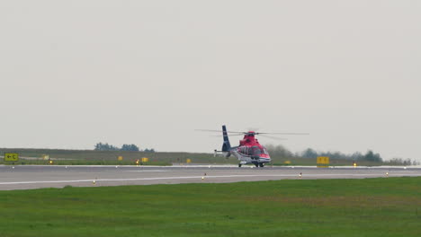 Un-Helicóptero-Rojo-En-La-Pista-De-Un-Aeropuerto,-Preparándose-Para-El-Despegue-O-El-Aterrizaje.