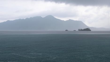Dramatic-grey,-cloudy-and-wet-raining-day-overlooking-remote-tropical-island-and-ocean-in-Coron-Bay,-Palawan,-Philippines