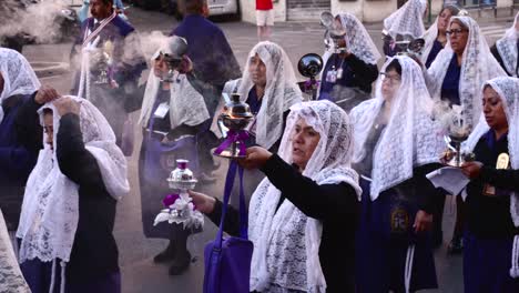 Peruanische-Frauen,-Die-Während-Der-Prozession-Des-Herrn-Der-Wunder-Mit-Weihrauch-Und-Mit-Einem-Schleier-Bedecktem-Kopf-Rückwärts-Gehen
