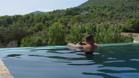 man-leaning-out-of-an-infinity-pool