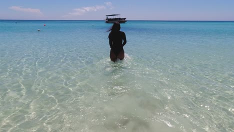 Long-hair-Hispanic-woman-walks-slo-mo-into-clear-warm-Caribbean-sea