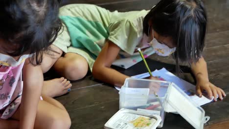 Asiatisches-Junges-Mädchen-Schreibt-Hausaufgabenheft,-Nahaufnahme