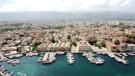 Vast-city-of-Chania-with-mountains-in-background,-aerial-drone-view