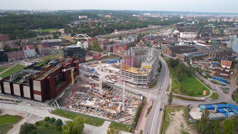 Aerial-shot-of-Gdansk-center,-featuring-the-bustling-construction-near-the-Solidarity-Museum-and-intertwining-roads