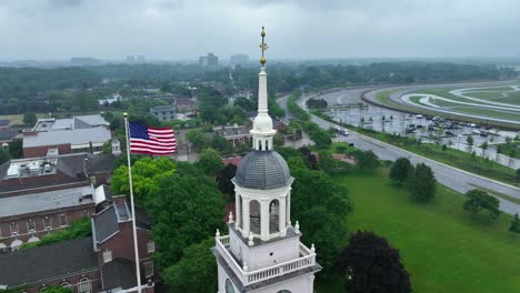 órbita-Aérea-Alrededor-Del-Museo-Henry-Ford-Y-La-Bandera-Estadounidense-En-Un-Día-Lluvioso-En-Dearborn,-Michigan