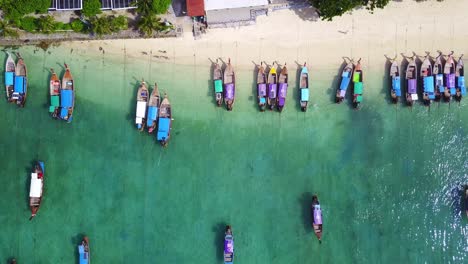 Beautiful-Top-Down-View-Over-Turquoise-Waters-and-Longtail-Boats,-Koh-Phi-Phi,-Thailand