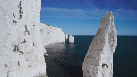 Low-Aerial-Shot-Through-Chalk-Cliff-Stacks-at-Old-Harry-Rocks,-Beatuiful-Clear-Day-in-England