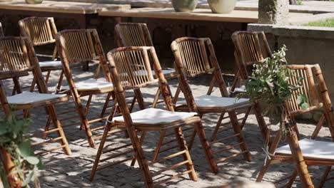 Outdoor-wedding-setup-with-wooden-chairs-in-European-village-courtyard