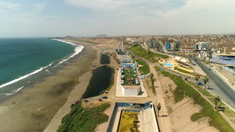 Drone-shot-flying-along-the-Playa-Chorillos-beach,-sunny-day-in-Huacho,-Peru
