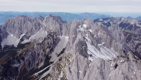 Aerial-of-steep-rocky-alpine-mountain-range,-ridge-with-peak-epic-landscape-drone-scenery-view-descending