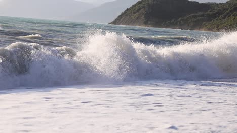 Zeitlupenaufnahme-Von-Schäumenden-Wellen,-Die-An-Einem-Sommertag-Am-Strand-Zerschlagen