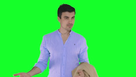 A-handsome-young-man-in-a-blue-shirt-holds-a-jacket-in-his-hand-and-looks-around-confused,-green-screen