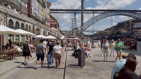 People-walking-on-the-banks-of-the-Douro-River-in-Porto,-Portugal