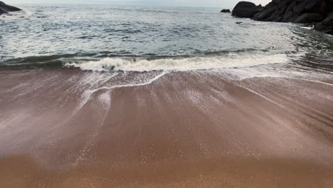 Wave-and-cloudy-blue-sky-Butterfly-Beach-Goa-India-4K-Tilt-Up