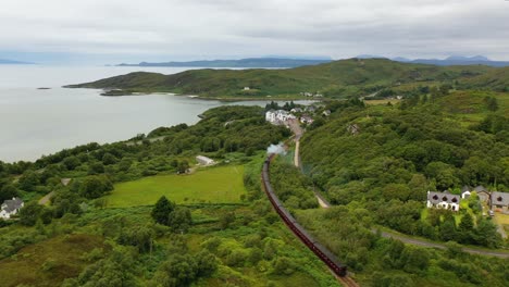 Aerial-View-Of-The-Jacobite-Steam-Train-Crossing-Through-Morar-In-Scotland,-West-Coast-of-Scotland