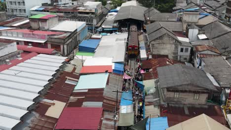 Aerial-view-of-train-leaving-Mae-Klong-Railway-Market