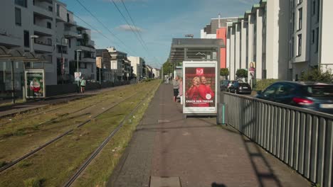 Push-in-to-waiting-area-at-platform-for-main-station-in-downtown-urban-setting-outside-at-susnet