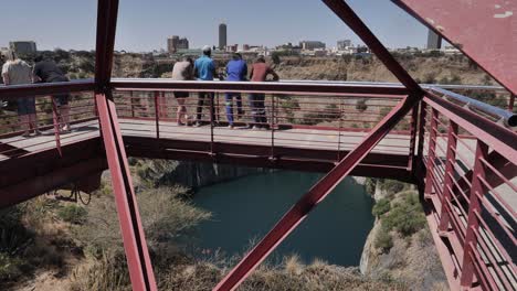 Tourists-view-the-Big-Hole-diamond-mine-from-viewing-bridge,-Kimberley