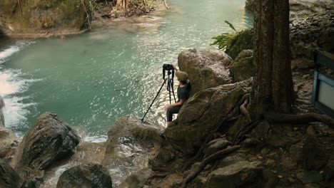 Fotógrafo-Con-Una-Cámara-DSLR-Sobre-Un-Trípode-Junto-A-Una-Cascada-En-El-Parque-Nacional-De-Erawan