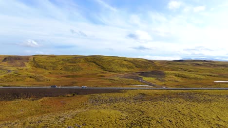 Aerial-tracking-shot-of-a-white-SUV-driving-through-the-Icelandic-countryside